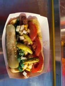 Photo of a hot dog, a type of sandwich, with various toppings